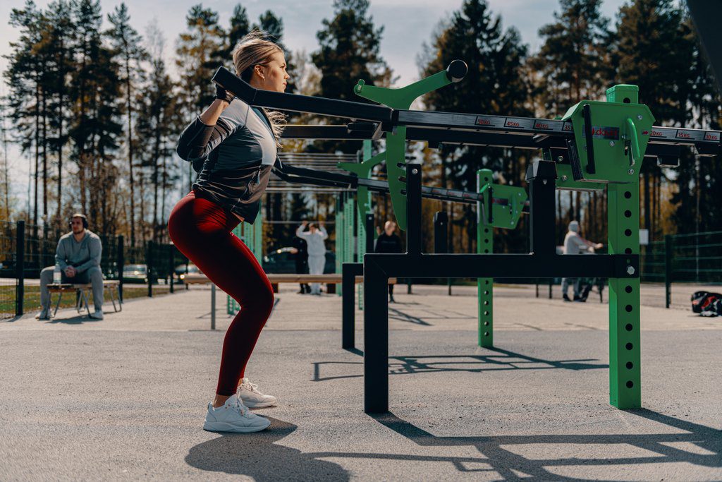 Mies tekemässä penkkipunnerrusta talvella ulkokuntosalilla Helsingissä