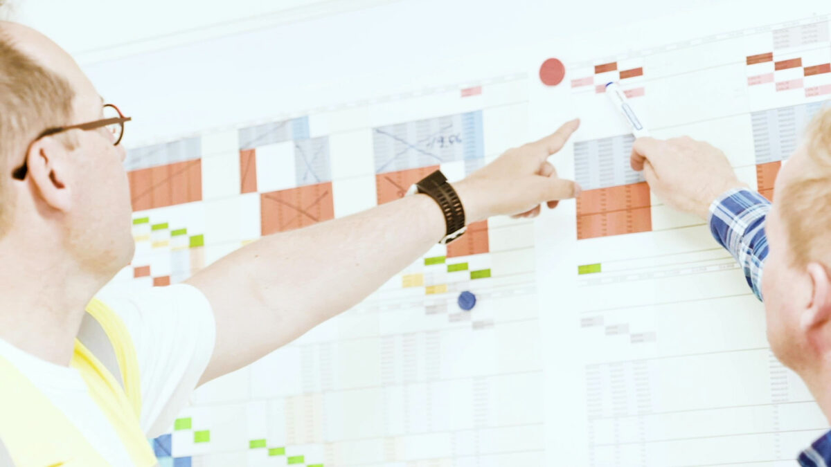 People Review The Project Schedule For A Construction Site.